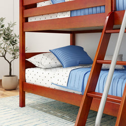 Wooden bunk bed with blue bedding and star-patterned sheets in a cozy bedroom setting.