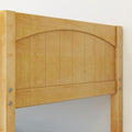 Close-up of light maple wood arched headboard with vertical plank panels and visible metal bolts