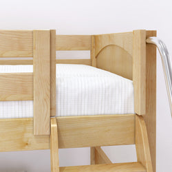 Wooden bunk bed corner with white bedding and metal ladder.