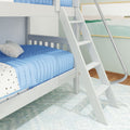 White wooden bunk bed ladder next to blue quilted bedding in modern children's bedroom — kids loft bed and nursery decor