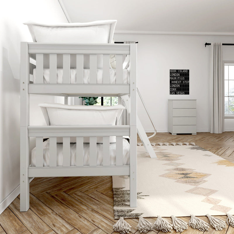 White wooden bunk bed in modern minimalist kids bedroom with ladder, tassel boho rug, herringbone wood floor and white dresser