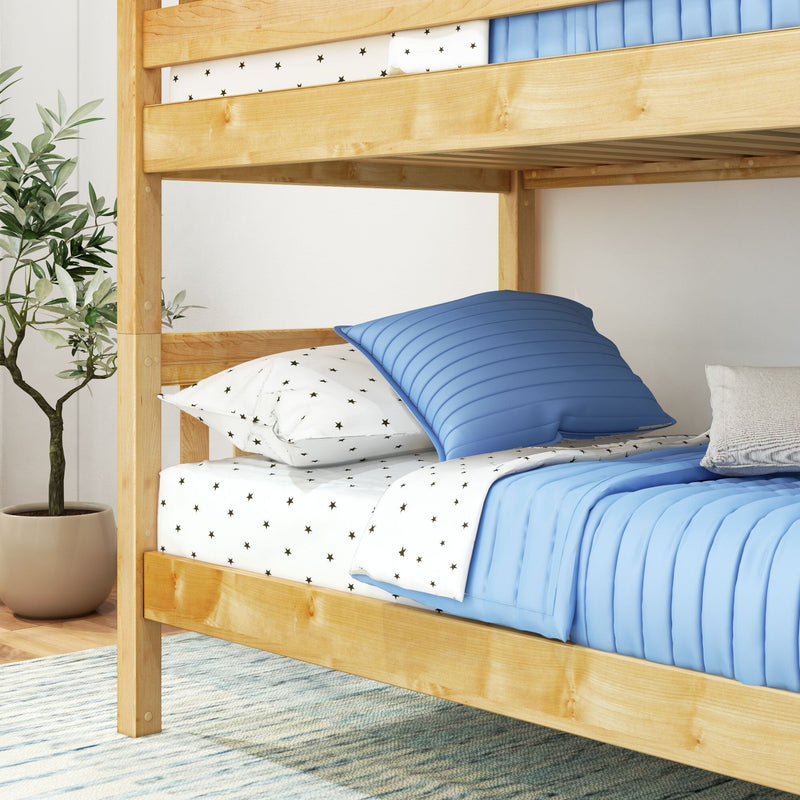 Modern natural wood bunk bed with blue quilted bedding and star-print white sheets in a cozy kids' bedroom with potted plant