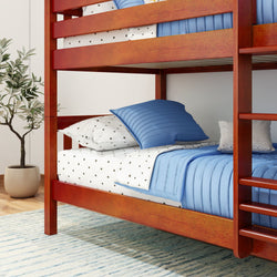 Red wooden bunk bed with blue bedding and star-patterned sheets in a cozy bedroom setting.