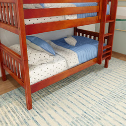 Wooden bunk bed with star-patterned bedding and blue pillows in a cozy bedroom.