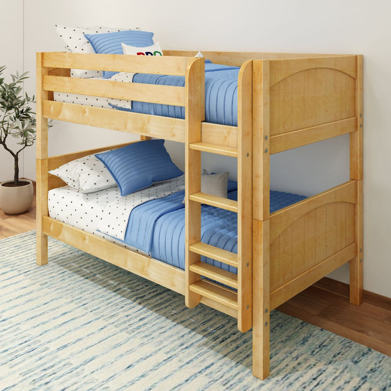 Solid natural wood twin-over-twin bunk bed with ladder and safety rails, blue quilted bedding and star-pattern sheets in modern kids' bedroom
