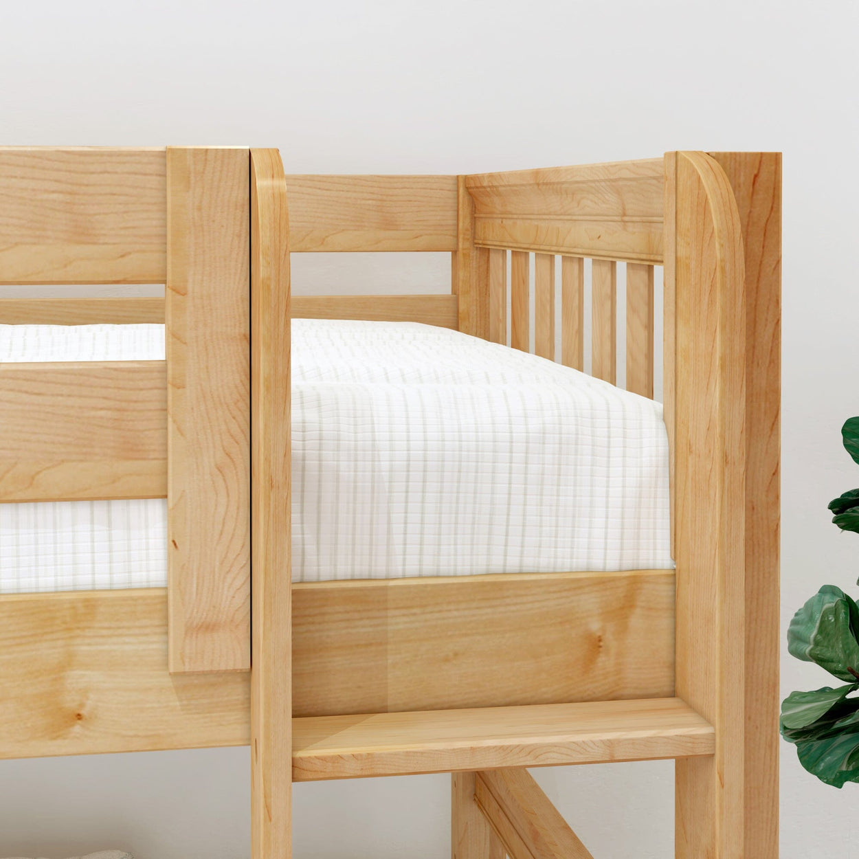 Close-up of natural maple wooden bunk bed with ladder and slatted guardrail, white quilted bedding in a modern children's bedroom
