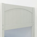 Close-up of white painted wooden garden gate with arched top, vertical tongue-and-groove panels and visible metal bolts