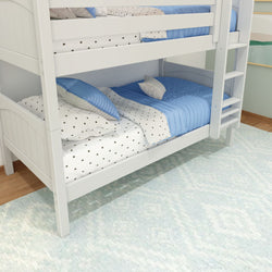 White bunk bed with blue and star-patterned bedding in a child’s bedroom.