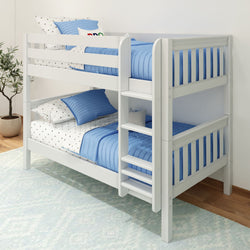 White wooden bunk bed with blue bedding and polka dot sheets, featuring a ladder and positioned on a light blue rug in a cozy children's bedroom.
