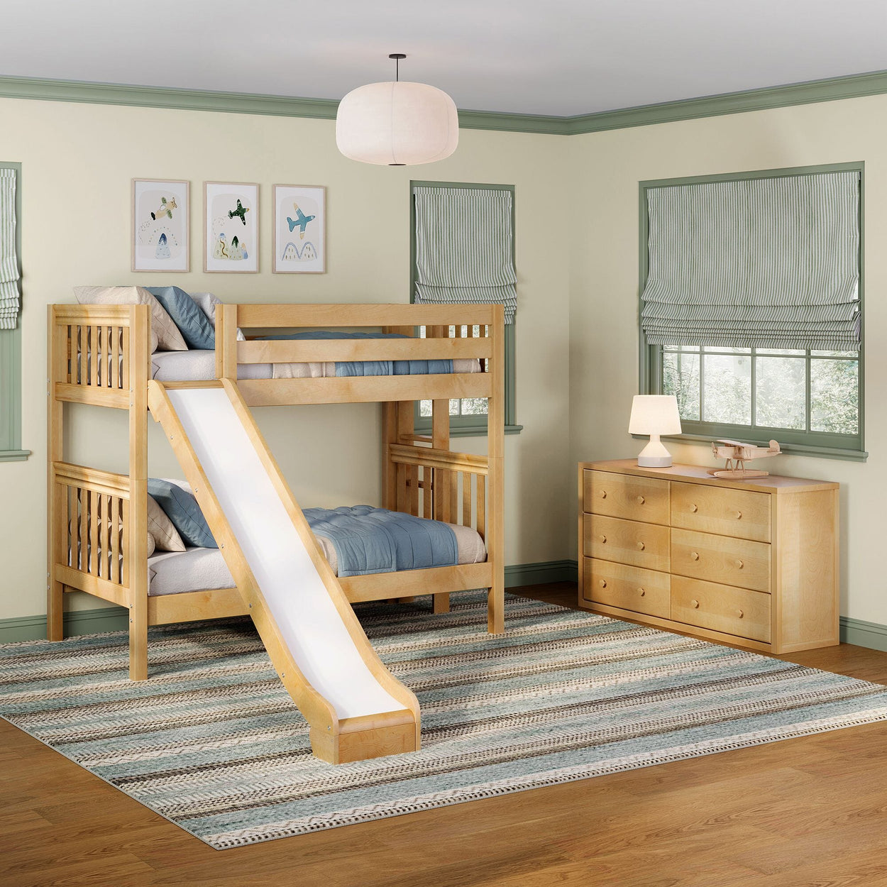 Natural wood kids bunk bed with slide, blue bedding, oak dresser, striped Roman shades and pendant light in a modern children's bedroom