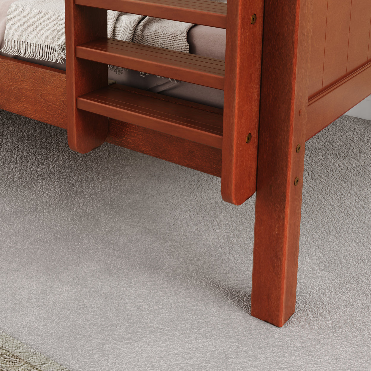 Wooden bunk bed ladder resting on soft carpet flooring.