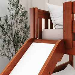 Kids' wooden loft bed with slide and white pillow, indoor plant decor.