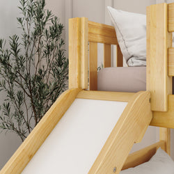 Wooden loft bed with slide and pillow, next to an olive tree plant in a modern bedroom setting.