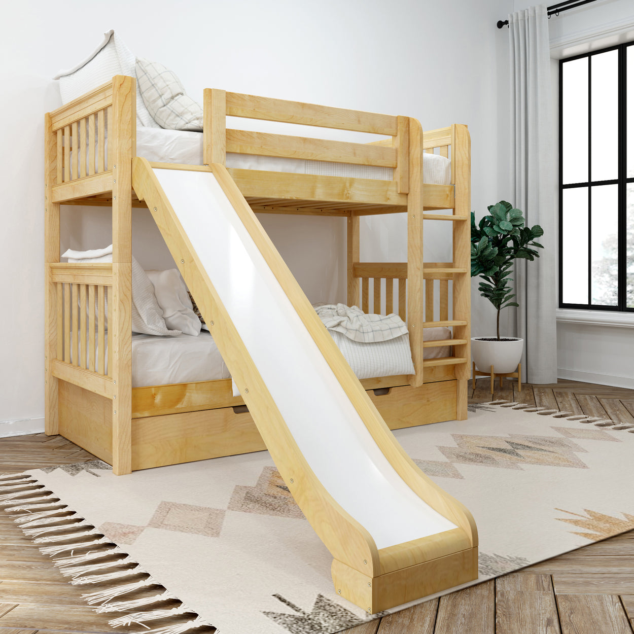 Wooden bunk bed with slide in a bright children's room, featuring a cozy layered mattress with pillows and a modern indoor plant.