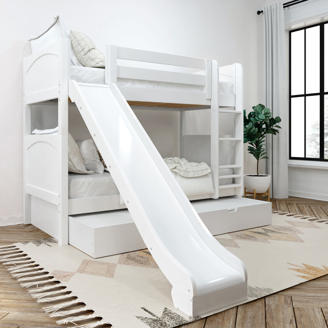White kids' bunk bed with slide in a bright, modern bedroom featuring cozy bedding, a rug, and a potted plant.