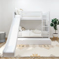 White wooden bunk bed with slide and pull-out trundle drawer in modern children's bedroom with ladder, neutral bedding and decorative rug