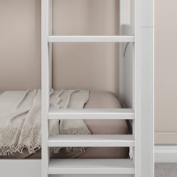 White bunk bed interior with beige bedding and a cozy blanket in a modern bedroom setting.