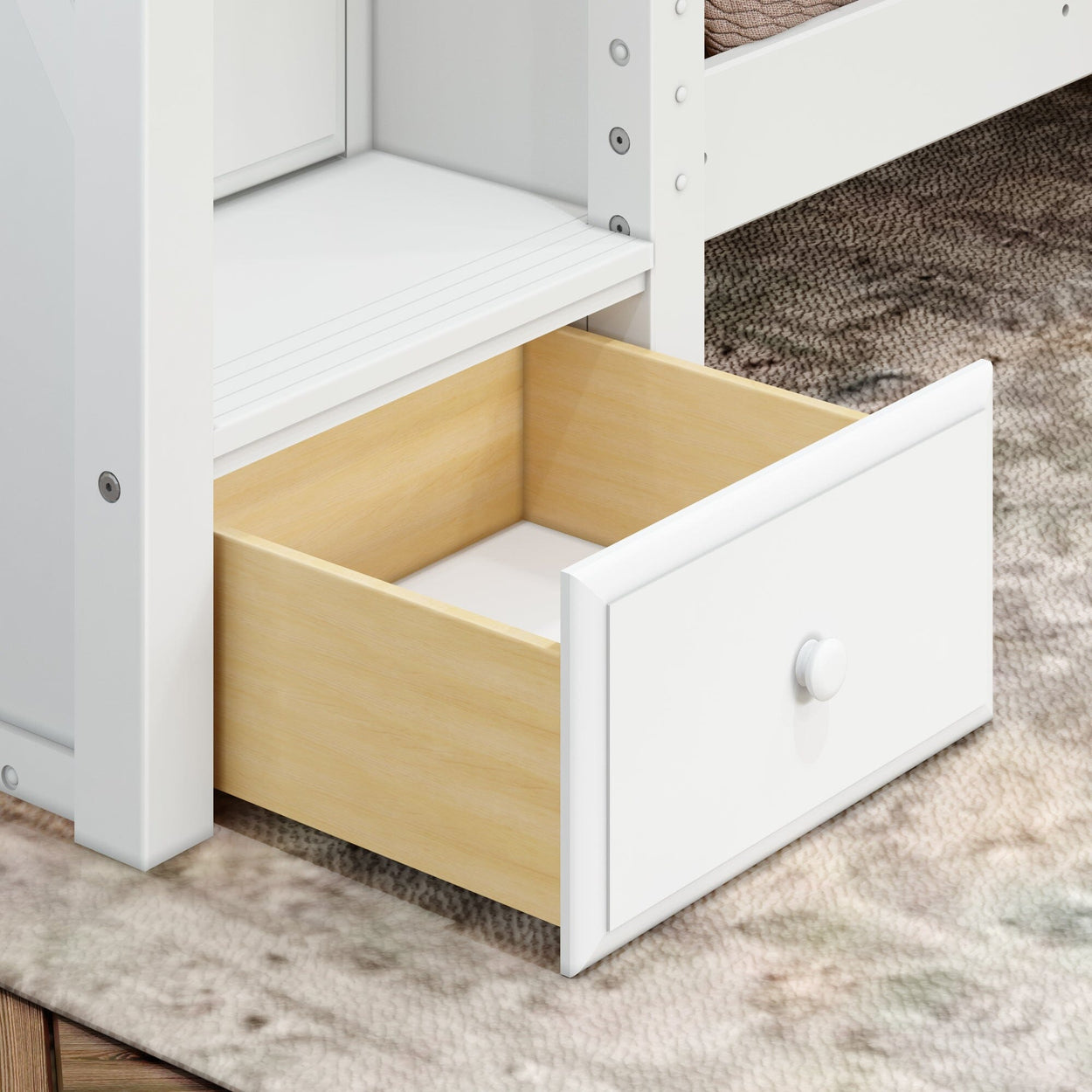 Open white wooden drawer on carpeted floor in modern home interior.