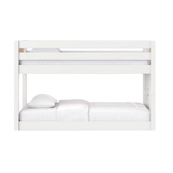 White wooden twin-over-full bunk bed with safety rails and white bedding in a modern kids' bedroom