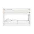 White wooden twin-over-full bunk bed with safety rails and white bedding in a modern kids' bedroom