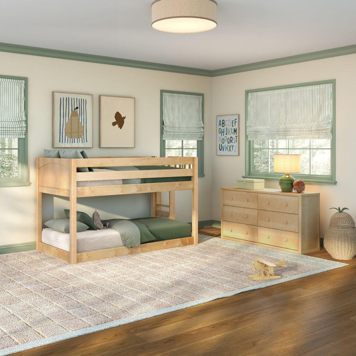 Kids bedroom with natural wood twin bunk bed, green bedding, wooden dresser, striped roman shades, alphabet wall art and wooden toy airplane