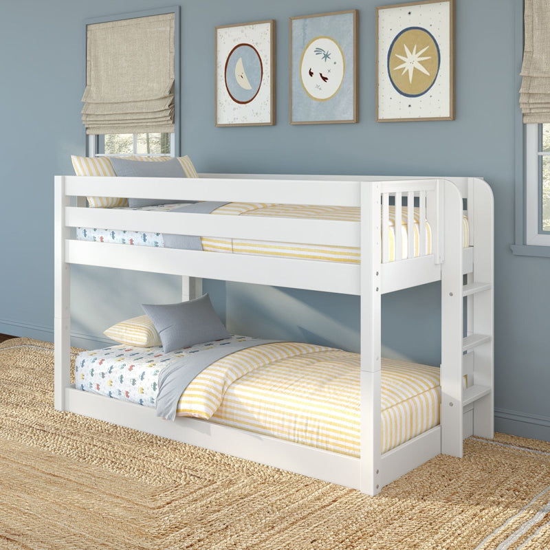 White wooden twin-over-twin bunk bed in blue kids' bedroom with yellow striped bedding, moon and star framed prints, jute rug