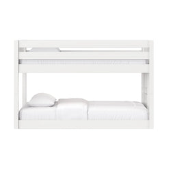 White wooden bunk bed with guardrails and ladder, white bedding in modern kids' bedroom