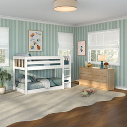 Children's bedroom with white twin-over-full bunk bed, teal striped wallpaper, wooden dresser, plush rug, potted plant and caterpillar toy by sunny windows