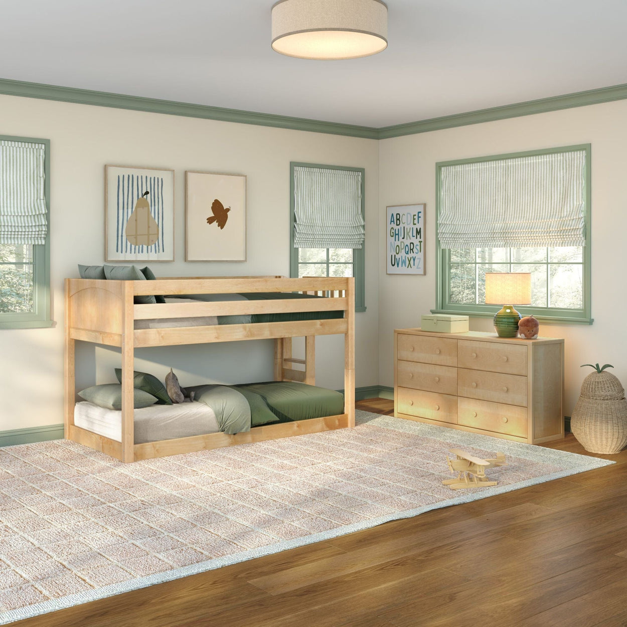 Natural wood bunk bed in children's bedroom with green bedding, dresser, ABC wall art, striped Roman shades, large area rug and hardwood floor