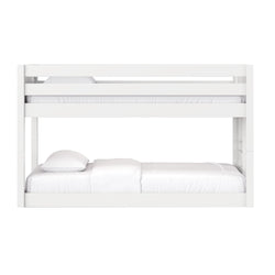 White wooden bunk bed with safety guardrails and white mattresses and pillows, modern loft-style design for kids' bedroom
