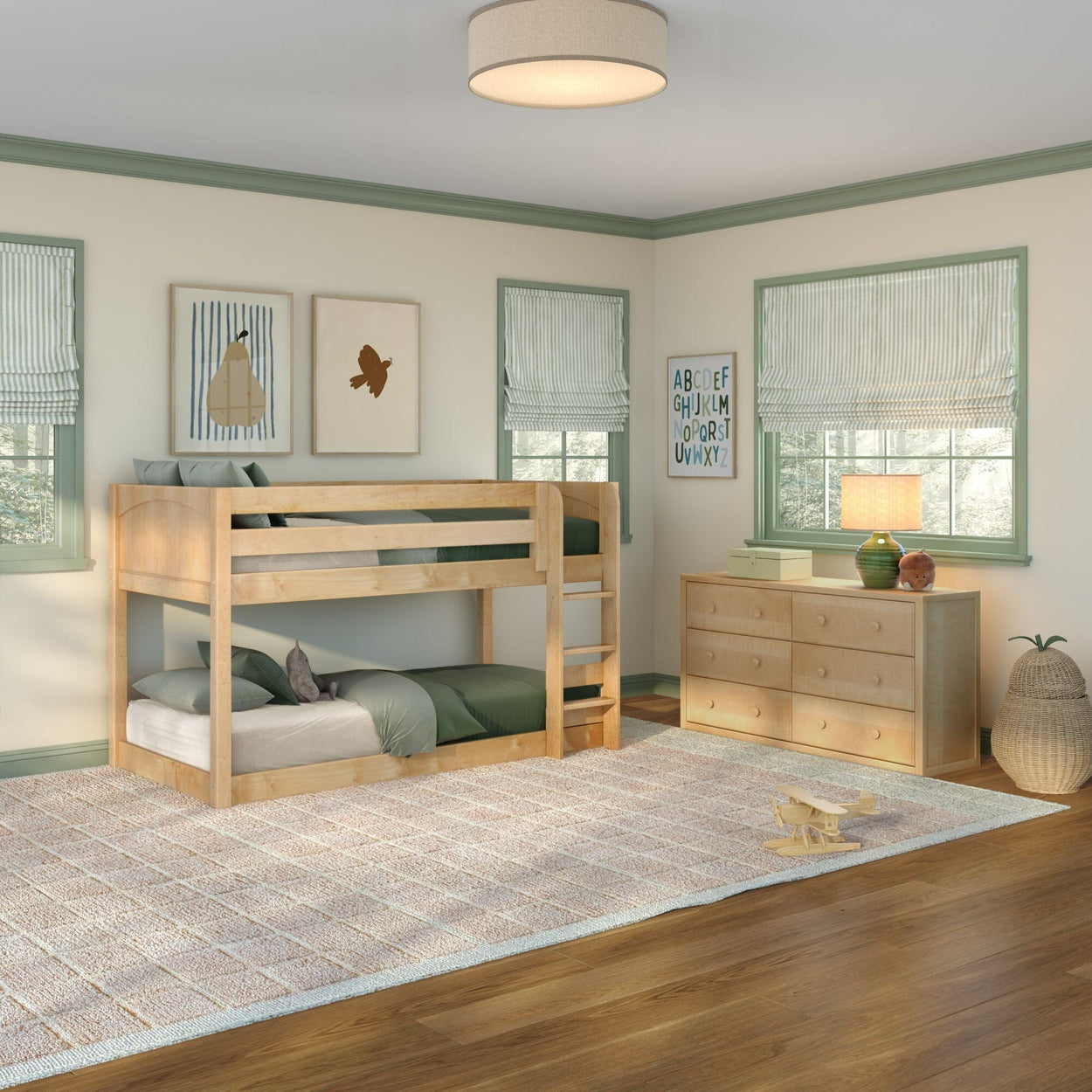 Natural wood bunk bed in modern kids bedroom with green bedding, light wood dresser, striped Roman shades, alphabet wall art, beige area rug and hardwood floor