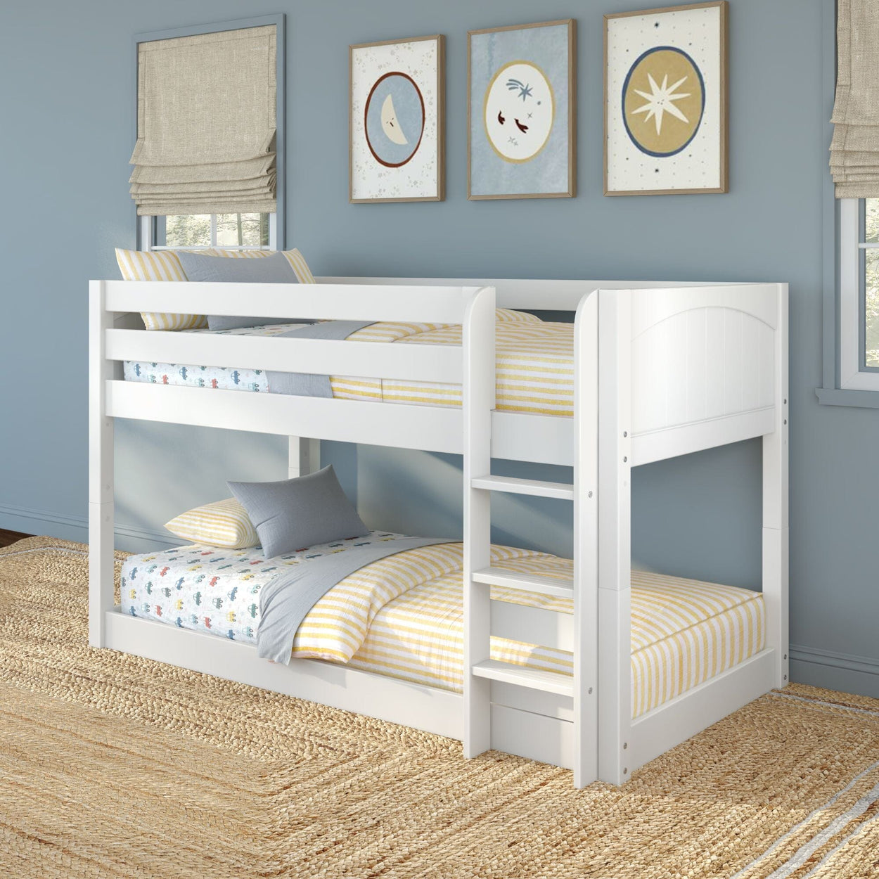 White wooden twin-over-twin bunk bed with ladder in coastal kids' bedroom, yellow-striped bedding, nautical wall art and blue walls