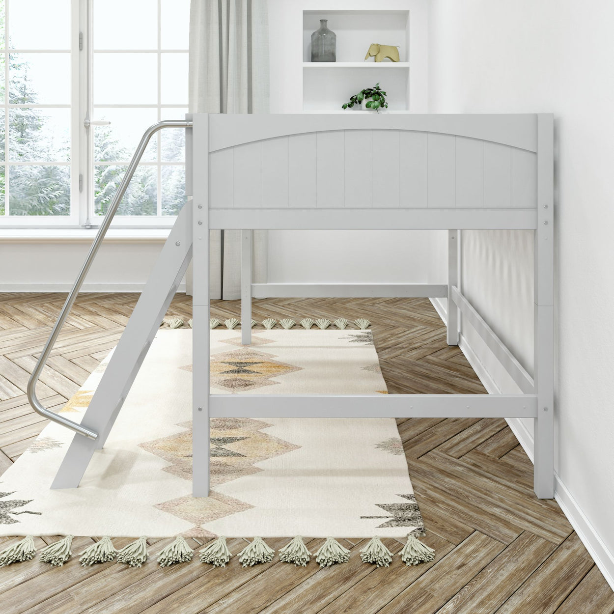 White wooden loft bed with slide in a bright modern bedroom with natural light and decorative rug.