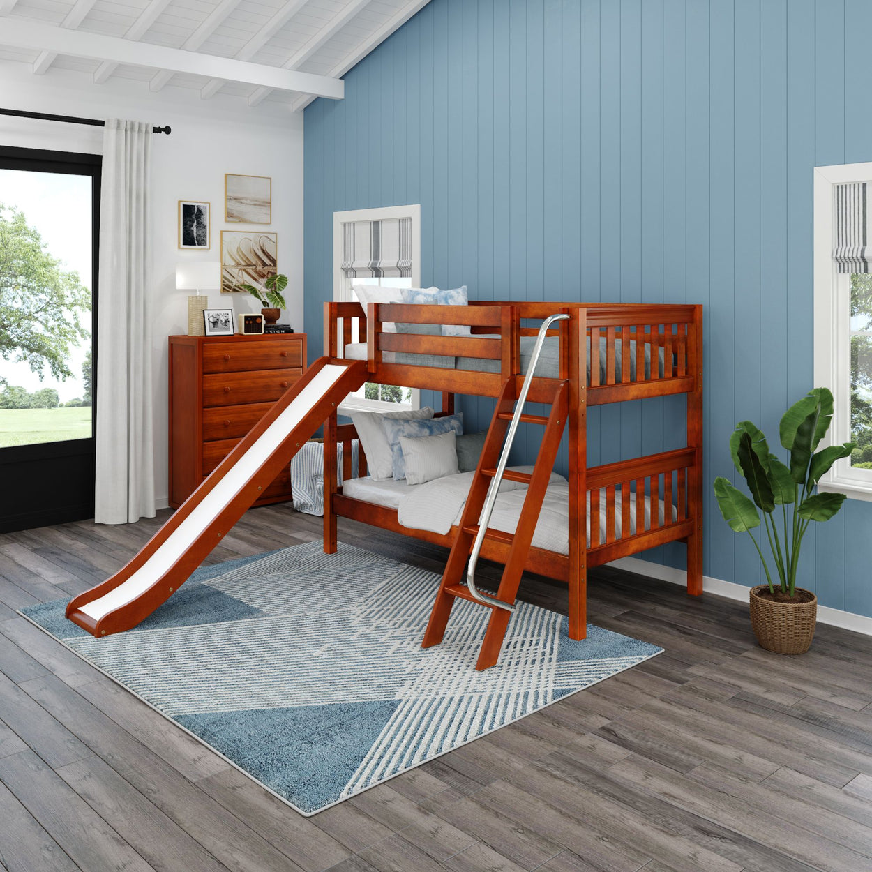 Kids wooden bunk bed with slide in modern blue bedroom, featuring ladder and potted plant on hardwood floor.