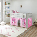 Bright kids bedroom with a white wooden loft bed featuring pink playhouse curtains, pink pillows, built-in white shelves with books and toys, and a cream-and-pink patterned rug