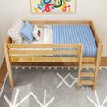 Wooden kids loft bed with light blue quilted mattress, star-print sheets and pillows, ladder, colorful abstract wall art and gray geometric rug