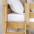 Close-up of light wooden bunk bed with ladder, white striped bedding and pillows, natural wood-grain finish and cozy neutral throw in kids' bedroom