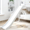 Modern white children's bunk bed with slide and built-in shelves, neutral bedding and patterned pillows, decorative plant, alarm clock and woven basket on herringbone hardwood floor in a bright minimalist kids' bedroom