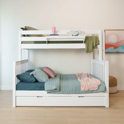 White wooden bunk bed with storage drawers, pastel teal and pink bedding, green knit throw and plush dinosaur toy in modern kids' bedroom