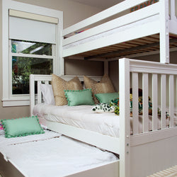 White bunk bed with trundle and green decorative pillows in a cozy bedroom setting.