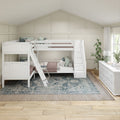 White bunk beds with staircase storage in a farmhouse-style shared kids' bedroom featuring a board-and-batten accent wall, soft pink quilts, patterned rug, white dresser and natural light