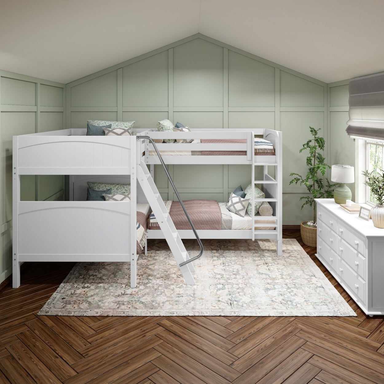 Attic bedroom with stylish white bunk bed, ladder, sage green accent wall, and herringbone wood floor.