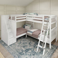 L-shaped white wooden bunk bed with built-in storage stairs and ladder, twin mattresses with mauve quilts and botanical throw pillows in a modern kids' bedroom with beige panel walls and patterned area rug