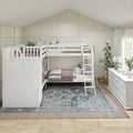Children's neutral bedroom with white wooden bunk beds, ladder, pink quilts, patterned rug, dresser, lamp and board-and-batten accent wall