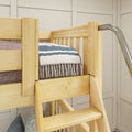 Natural wood bunk bed corner with built-in ladder and safety rails, navy striped quilt and tasseled throw in kids bedroom