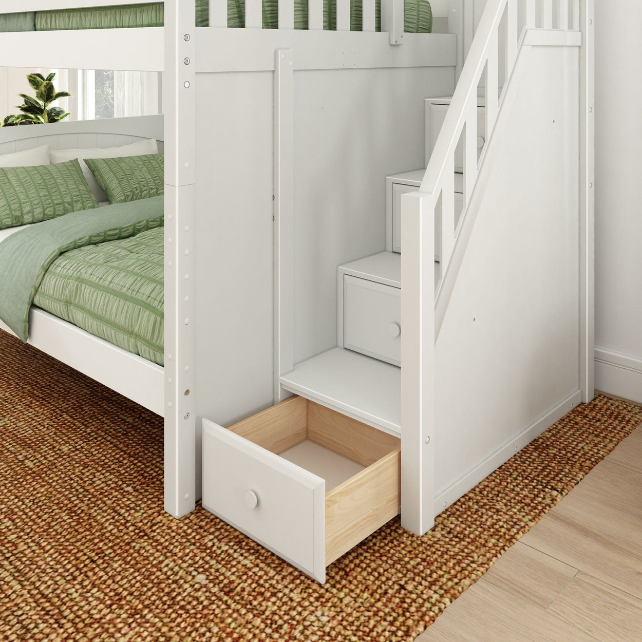 White wooden bunk bed with staircase and built-in under-stair storage drawer, green quilted bedding and woven jute rug in modern bedroom interior