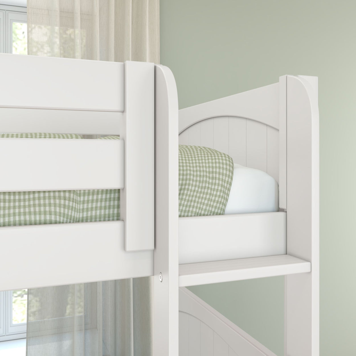 White wooden bunk bed with ladder and green gingham bedding in a children's bedroom with light green walls and sheer curtains