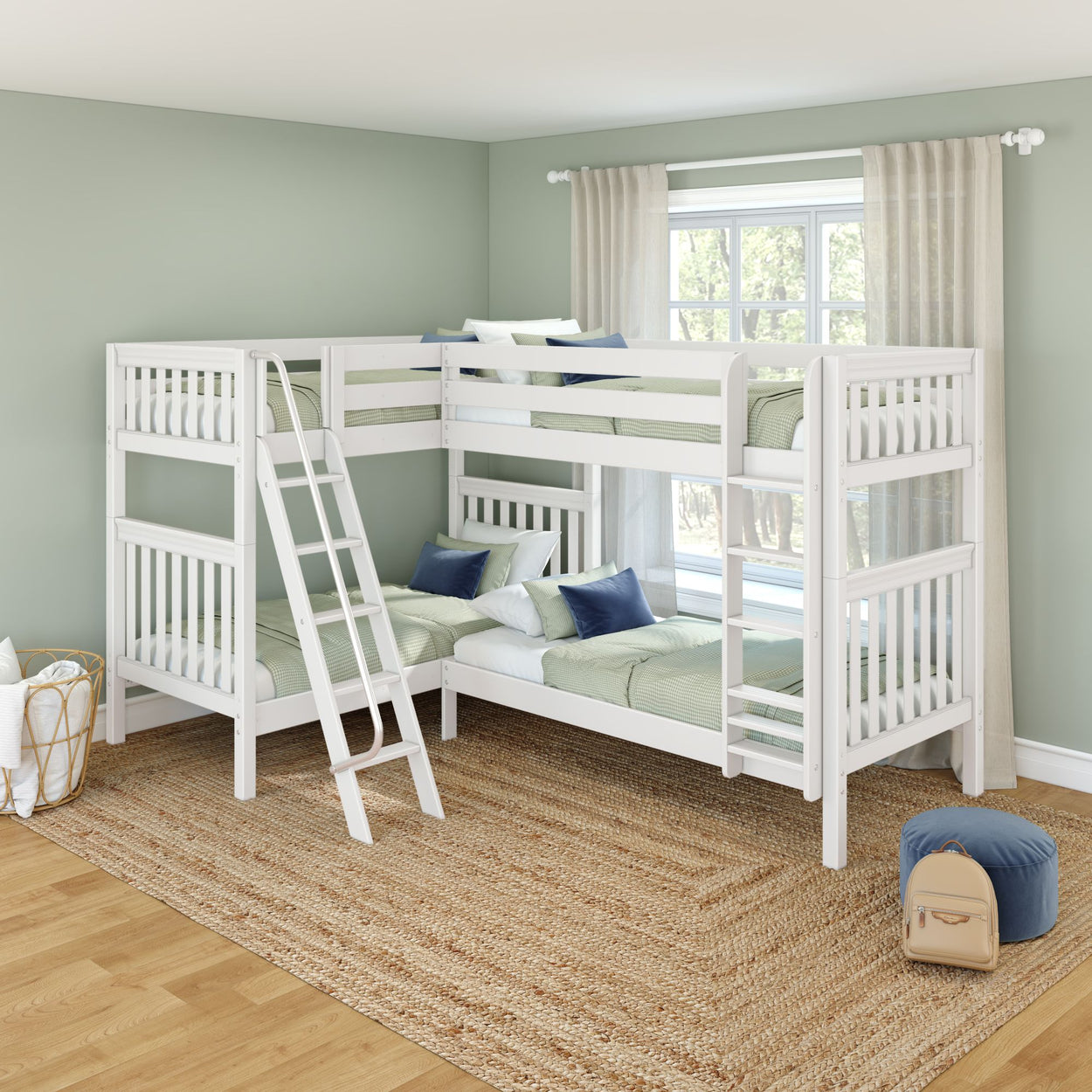 White L-shaped wooden kids bunk beds in a modern nursery with sage green walls, ladder, woven jute rug, navy and green pillows, and sheer curtains