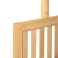 Natural wooden slatted headboard close-up showing dowel-peg joinery on a light pine bed frame