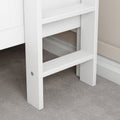 White wooden ladder steps on carpeted floor near wall, minimalist furniture design.